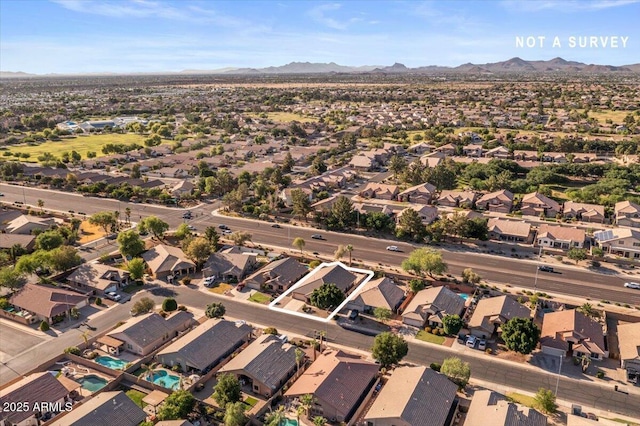 aerial view of property and surrounding area with a mountainous background and nearby suburban area