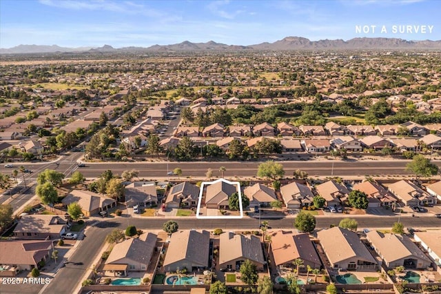 aerial view of property's location with nearby suburban area and a mountainous background