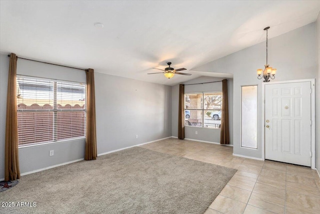 foyer featuring a chandelier, vaulted ceiling, a ceiling fan, light tile patterned floors, and baseboards