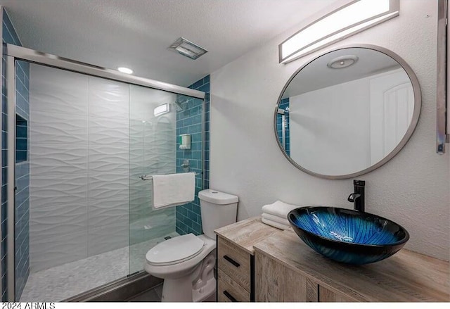 bathroom featuring toilet, vanity, and an enclosed shower