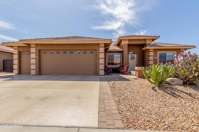 prairie-style house with stucco siding, an attached garage, and concrete driveway