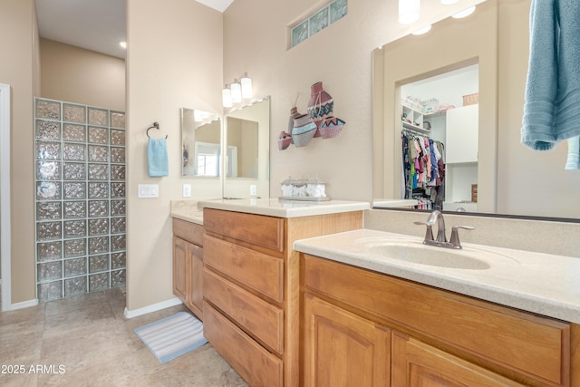 full bath with baseboards, tile patterned flooring, vanity, and walk in shower