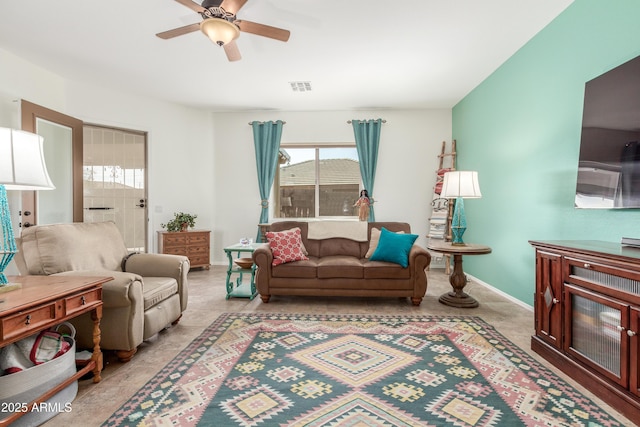 living room featuring a ceiling fan, visible vents, a wealth of natural light, and baseboards