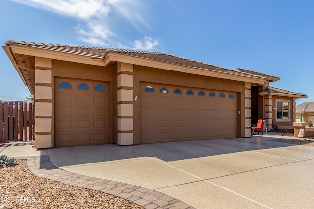 prairie-style home with stucco siding, a garage, and driveway