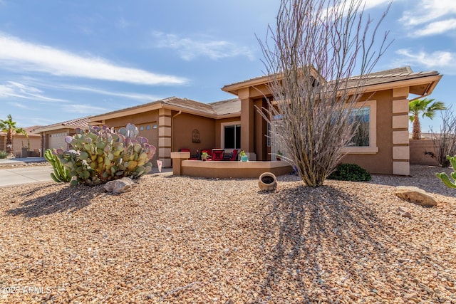 view of front facade featuring an attached garage, driveway, and stucco siding