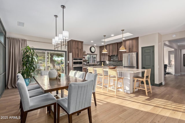 dining space featuring a chandelier and light hardwood / wood-style flooring