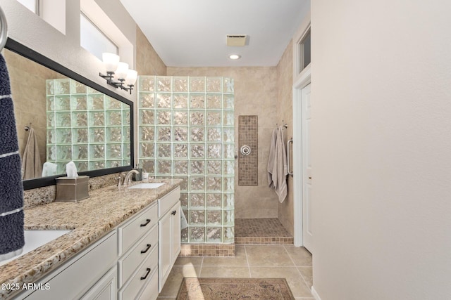 bathroom featuring vanity, tile patterned floors, and tiled shower