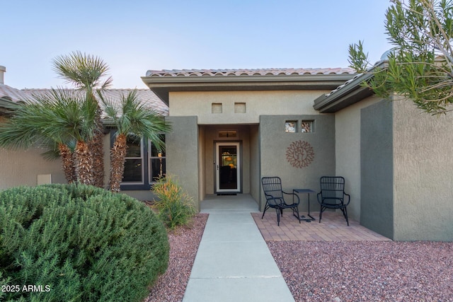 view of exterior entry featuring a patio area