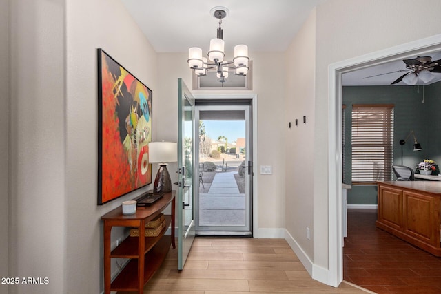 entrance foyer with ceiling fan with notable chandelier