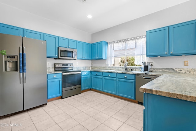 kitchen with blue cabinetry, stainless steel appliances, and sink