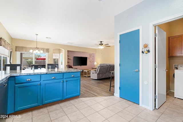 kitchen with pendant lighting, black dishwasher, blue cabinets, light tile patterned flooring, and washer / dryer