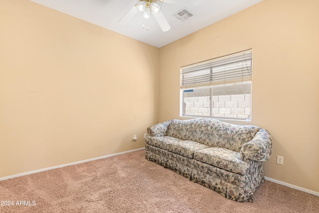 sitting room with ceiling fan and carpet