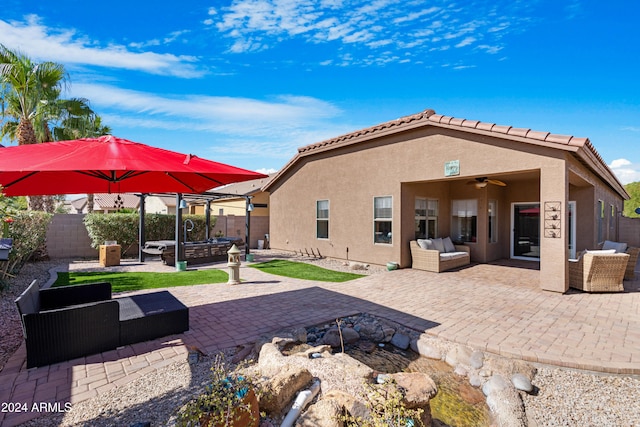 back of property with outdoor lounge area, a patio, and ceiling fan