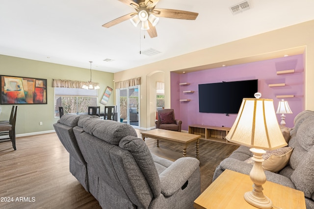 living room featuring hardwood / wood-style flooring and ceiling fan with notable chandelier