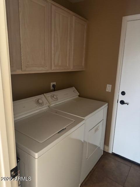 washroom featuring cabinets, washing machine and dryer, and dark tile patterned floors