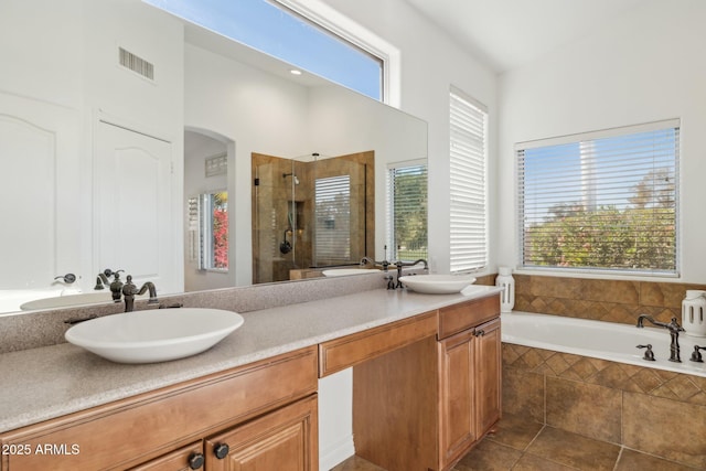 bathroom featuring vanity, tile patterned flooring, and plus walk in shower