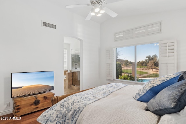 bedroom with hardwood / wood-style floors, ensuite bath, vaulted ceiling, and ceiling fan