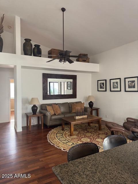 living room featuring ceiling fan, dark hardwood / wood-style flooring, and a high ceiling