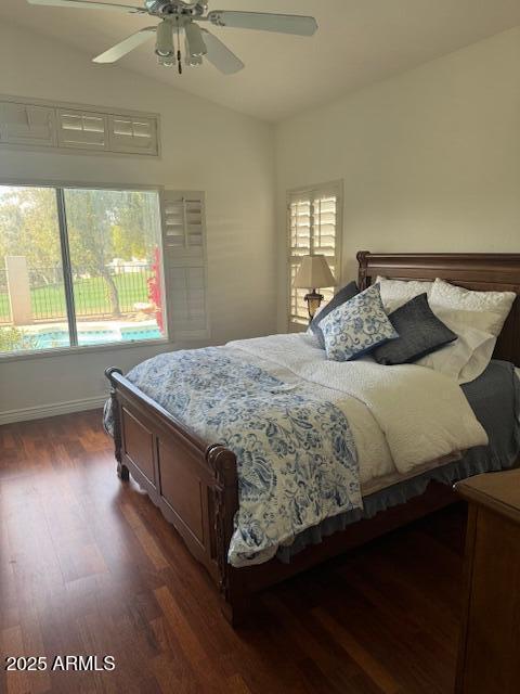 bedroom with dark wood-type flooring, vaulted ceiling, and ceiling fan