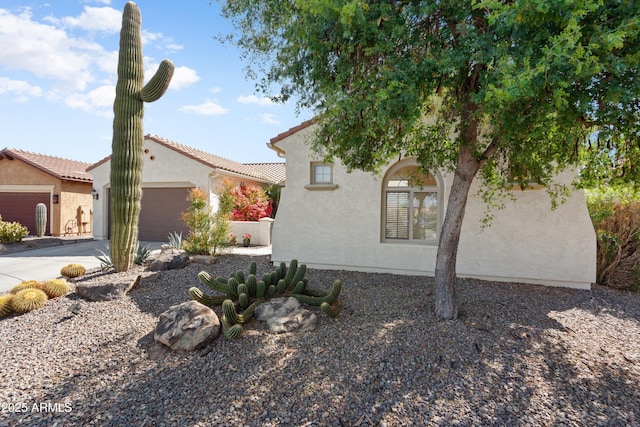 view of home's exterior with stucco siding, driveway, and an attached garage