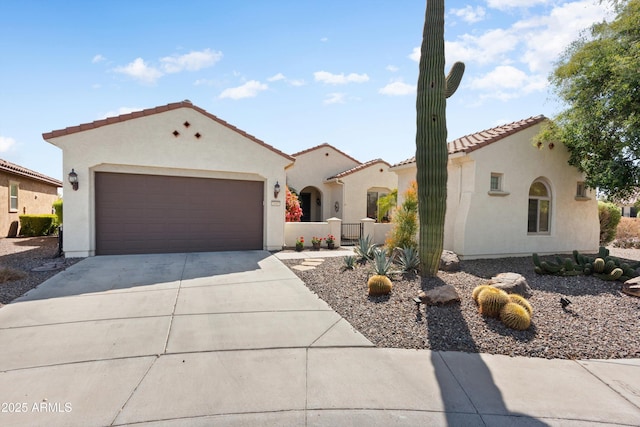 mediterranean / spanish-style home featuring a tile roof, concrete driveway, a garage, and stucco siding