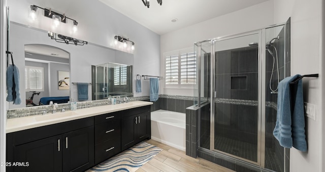 bathroom with hardwood / wood-style flooring, vanity, and shower with separate bathtub