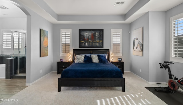 carpeted bedroom with a tray ceiling