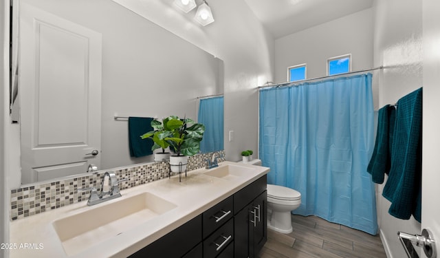 bathroom with hardwood / wood-style flooring, vanity, decorative backsplash, toilet, and walk in shower