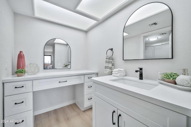 bathroom featuring hardwood / wood-style floors, vanity, and walk in shower