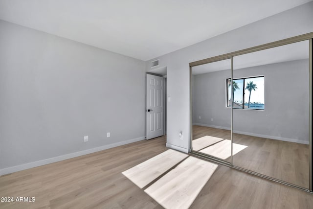 unfurnished bedroom with light hardwood / wood-style floors and a closet