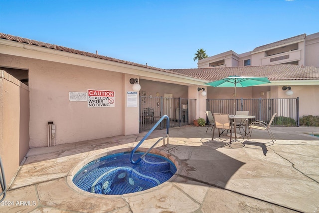 view of swimming pool with a patio area and a hot tub