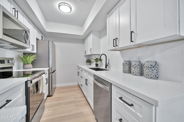 kitchen with sink, white cabinets, and stainless steel appliances