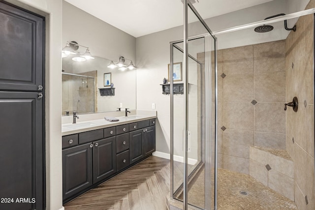 bathroom featuring parquet flooring, vanity, and a shower with shower door