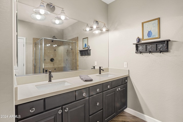 bathroom featuring an enclosed shower, vanity, and wood-type flooring