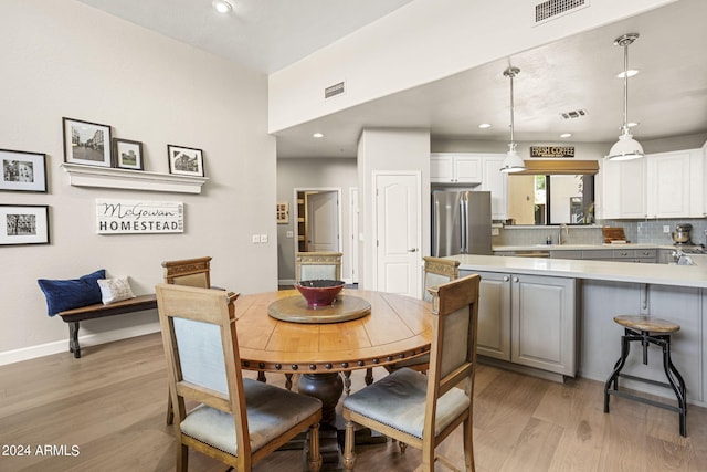 dining area with sink and light wood-type flooring