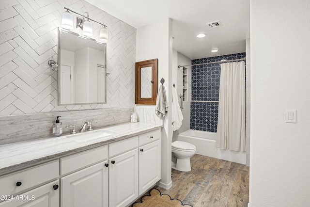 full bathroom with hardwood / wood-style floors, backsplash, vanity, toilet, and shower / bath combo