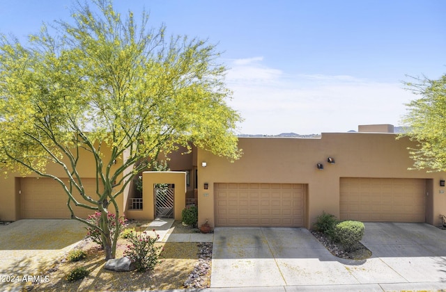 pueblo revival-style home with a garage