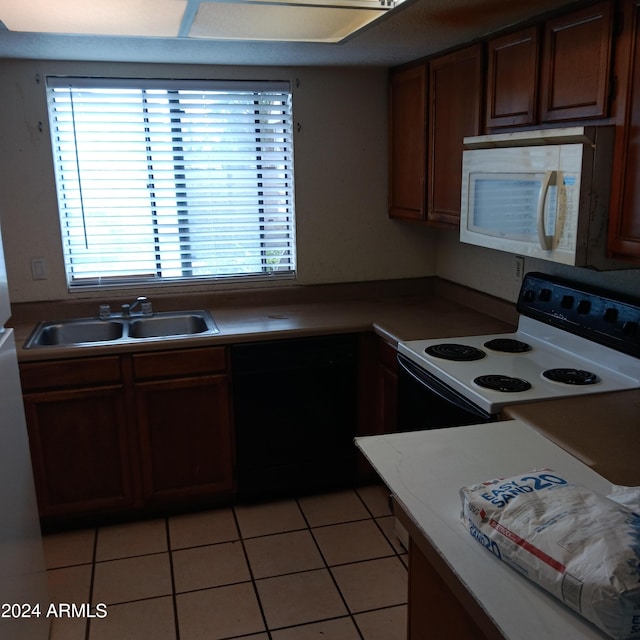 kitchen featuring light tile patterned flooring, white appliances, and sink