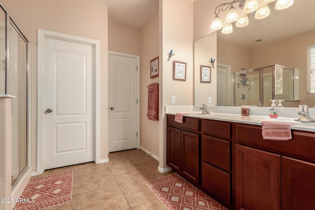bathroom featuring tile patterned flooring, a stall shower, a chandelier, and double vanity