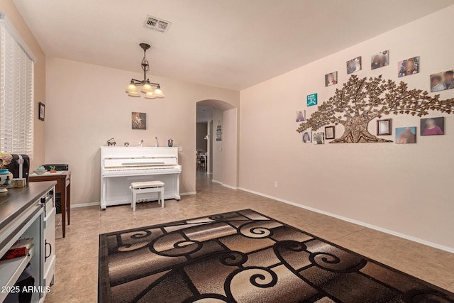 dining room with arched walkways, light tile patterned flooring, baseboards, and a chandelier