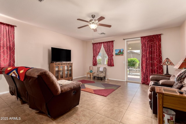living area featuring ceiling fan, light tile patterned floors, and baseboards