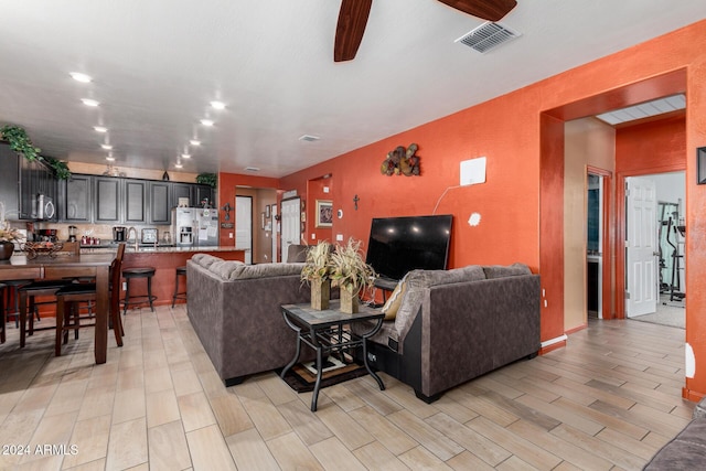 living room with ceiling fan and light hardwood / wood-style flooring