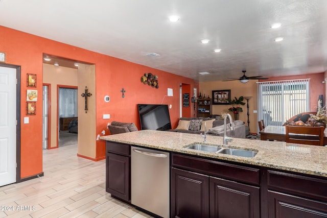 kitchen with light stone countertops, ceiling fan, dishwasher, sink, and light hardwood / wood-style flooring