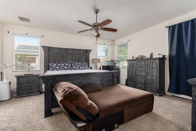 bedroom featuring multiple windows, ceiling fan, and light colored carpet