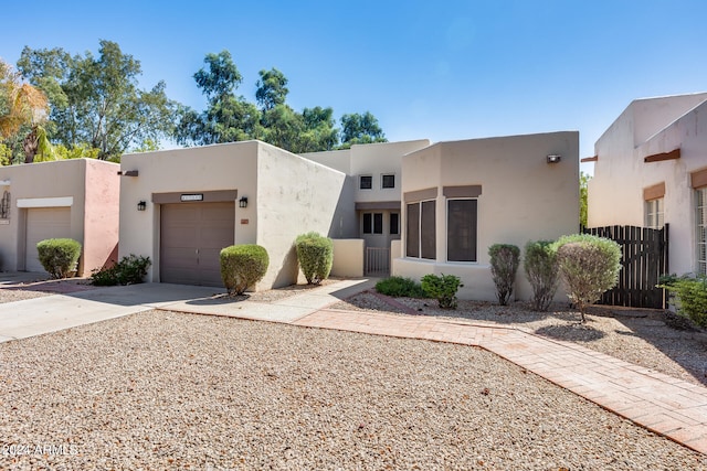 pueblo revival-style home featuring a garage