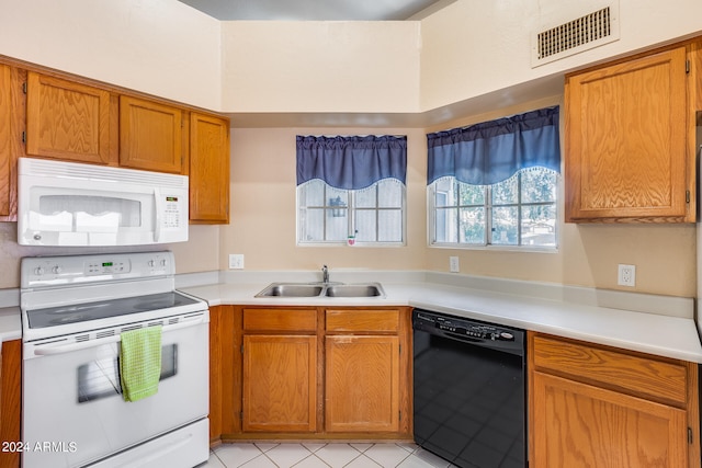 kitchen featuring sink, light tile patterned floors, and white appliances