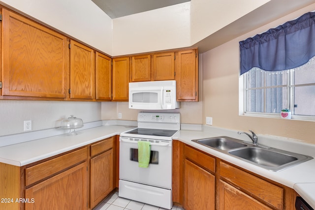 kitchen featuring white appliances, sink, and light tile patterned flooring