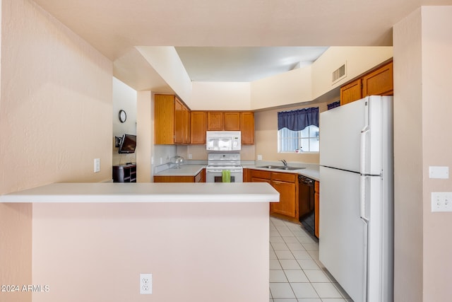 kitchen with light tile patterned floors, white appliances, kitchen peninsula, and sink