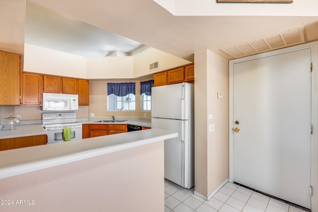 kitchen featuring light tile patterned floors, white appliances, kitchen peninsula, and sink