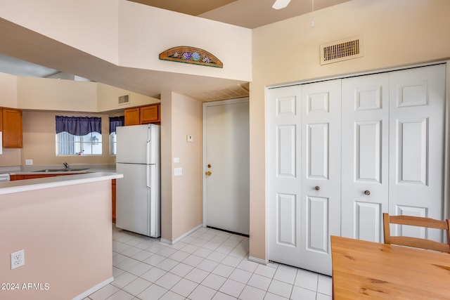 kitchen with white fridge, light tile patterned floors, and sink